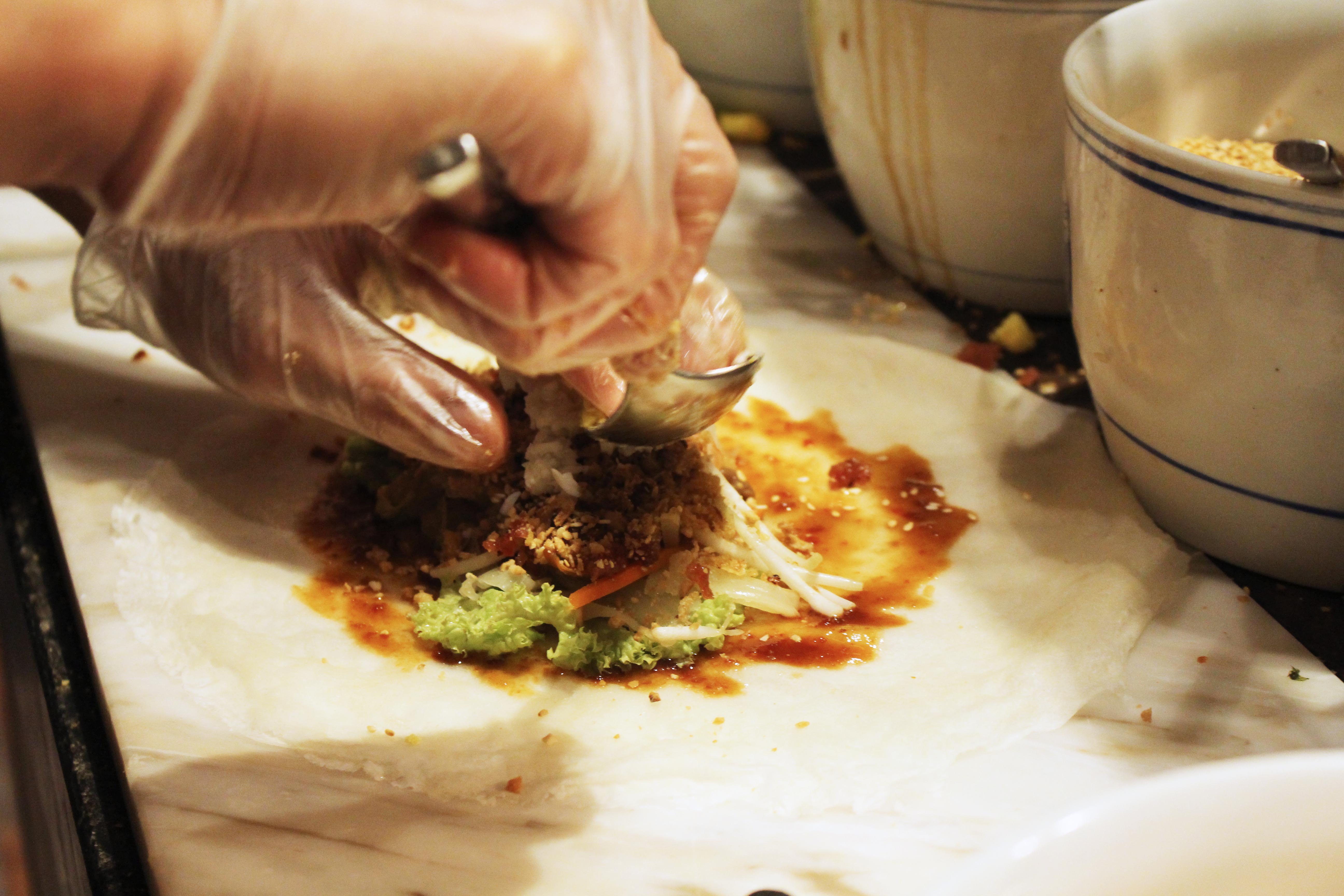 A close-up shot of the chef making popiah on the spot.